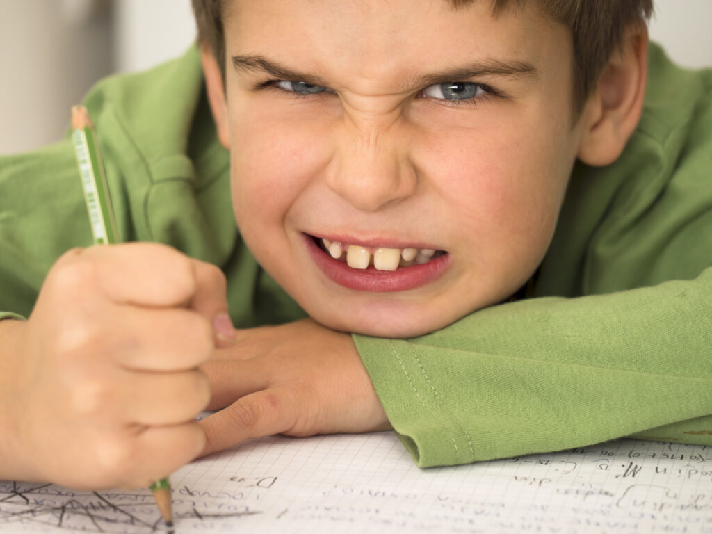 frustrated boy doing homework -writng patch